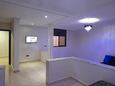 a living room with a couch and a tv at Apartament Ines in Skhirat