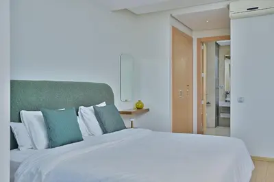 a bedroom with a large white bed with blue pillows at YourPlace - Modern, Spacious 3BR in Prestigia in Rabat