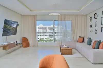 a living room with a couch and a tv at YourPlace - Modern, Spacious 3BR in Prestigia in Rabat