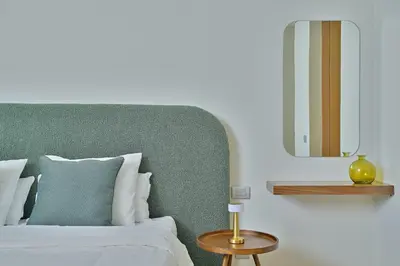 a bedroom with a bed with a green headboard and a table at YourPlace - Modern, Spacious 3BR in Prestigia in Rabat
