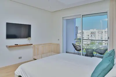 a bedroom with a bed and a large window at YourPlace - Modern, Spacious 3BR in Prestigia in Rabat