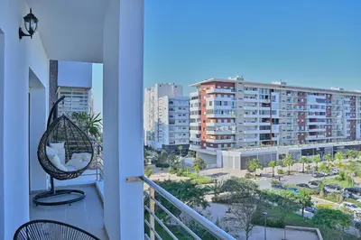 a balcony with a chair and a view of a city at YourPlace - Modern, Spacious 3BR in Prestigia in Rabat