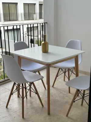a white table with chairs and a vase on it at 36 Studio luxueux corniche 5 min in Casablanca
