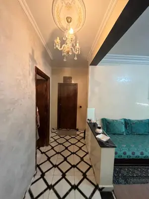 a living room with a chandelier and a blue couch at Oulfa in Casablanca