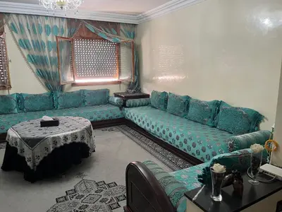 a living room with a blue couch and a table at Oulfa in Casablanca