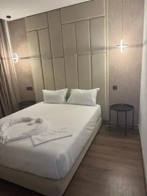 a bedroom with a large white bed with a headboard at 38 Studio luxueux- Corniche à 5 min in Casablanca