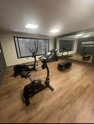 a gym with exercise bikes and a flat screen tv at 47 Appartement luxueux proche de la mer in Casablanca