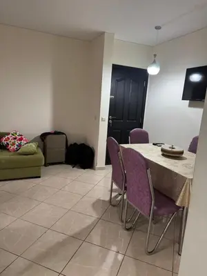 a living room with a table and purple chairs at Appartement calme in Tamaris