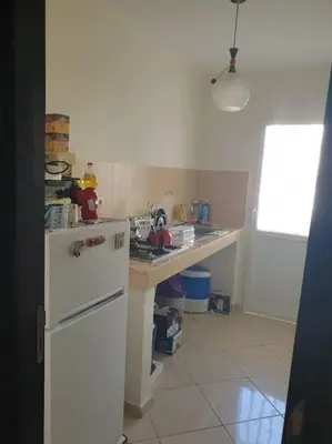 a kitchen with a white refrigerator and a counter at Appartement calme in Tamaris