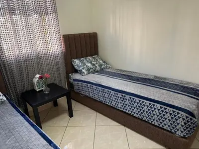 a small bedroom with a bed and a table at Appartement calme in Tamaris