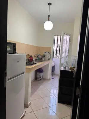 a kitchen with a white refrigerator and a counter at Appartement calme in Tamaris
