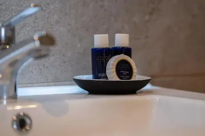 a bathroom sink with a blue bottle of soap on it at Appartement Prestige et Confort in Casablanca