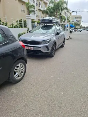 two cars parked in a parking lot next to a building at Les Jardins De Bouznika GHA4 in Bouznika