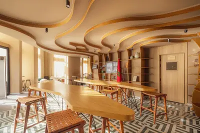 a row of tables in a room with wooden ceilings at Le Square By Onomo Collection in Casablanca