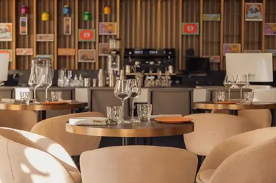 a restaurant with tables and chairs with wine glasses at Le Square By Onomo Collection in Casablanca