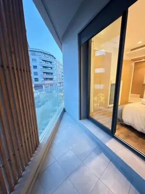 a room with a balcony with a bed and a window at Ideal home away from home in Maarif