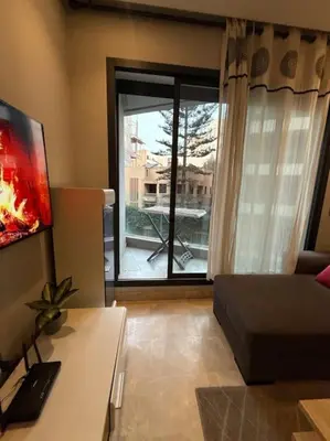 a living room with a couch and a large window at Ideal home away from home in Maarif