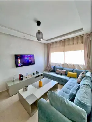 a living room with a blue couch and a tv at المعاريف in Casablanca