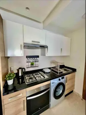a kitchen with a stove and a washing machine at المعاريف in Casablanca