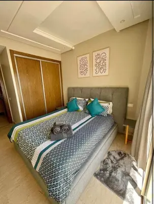 a bedroom with a large bed with blue pillows at المعاريف in Casablanca