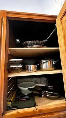 a wooden cabinet with some pots and pans in it at Ary déco flat in Casablanca city center in Casablanca