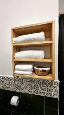 a bathroom with a shelf with towels and a basket at Ary déco flat in Casablanca city center in Casablanca