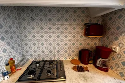 a kitchen counter with a stove top and a wall at Ary déco flat in Casablanca city center in Casablanca