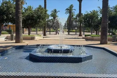 a fountain in the middle of a park with palm trees at Ary déco flat in Casablanca city center in Casablanca