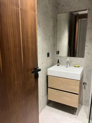a bathroom with a sink and a wooden door at Modern minimaliste retreat in Maarif in Casablanca