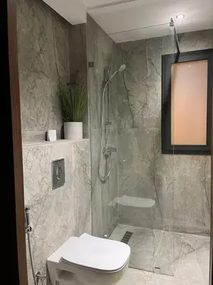 a bathroom with a shower with a toilet and a glass door at Modern minimaliste retreat in Maarif in Casablanca