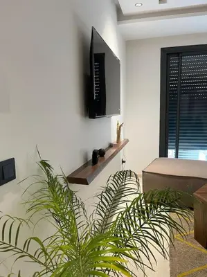 a living room with a tv and a plant at Modern minimaliste retreat in Maarif in Casablanca