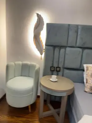 a room with a chair and a table and a bed at 2 Luxury BD apartment Near of Rabat Agdal Station in Rabat