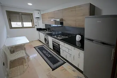a kitchen with a stove and a refrigerator and a table at 2 Luxury BD apartment Near of Rabat Agdal Station in Rabat