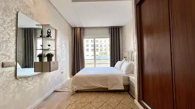 a bedroom with a bed and a mirror and a window at N8 appartement, 3 Chambres Haut de Gamme, a Deux Pas de l Ocean et du Mall in Rabat