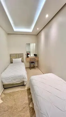 a bedroom with two beds and a mirror at N8 appartement, 3 Chambres Haut de Gamme, a Deux Pas de l Ocean et du Mall in Rabat