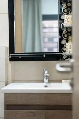 a bathroom with a sink and a mirror and a sink at Chic 2 chambres balcon vue panoramique et piscine in Aïn Harrouda