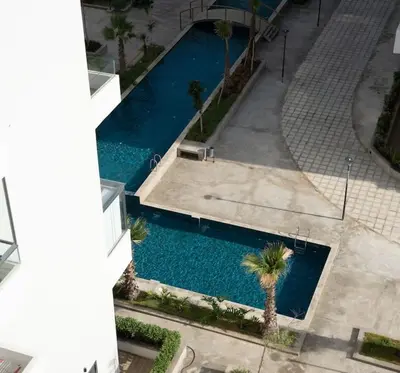an overhead view of a swimming pool with palm trees at Chic 2 chambres balcon vue panoramique et piscine in Aïn Harrouda