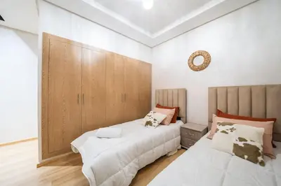 a bedroom with two beds and a mirror on the wall at Magnifique 2 chambres, vue panoramique et piscine in Casablanca