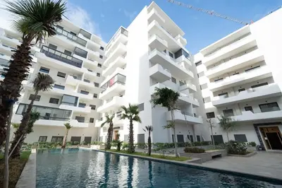 an apartment building with a swimming pool and palm trees at Magnifique 2 chambres, vue panoramique et piscine in Casablanca