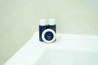 two bottles ofodorizers sitting on a white table at Appartement avec Piscine Proche Plage in Bouznika