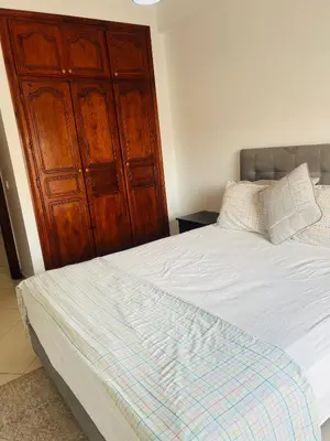 a bedroom with a bed and a wooden cabinet at Lovely 2 bedrooms Furnished Bourgogne in Casablanca