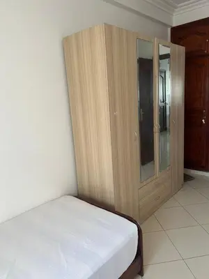 a bedroom with a bed and a wooden cabinet at Lovely 2 bedrooms Furnished Bourgogne in Casablanca