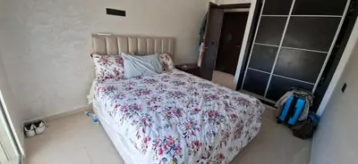 a bedroom with a bed with a floral bedspread at Residence la corniche d in Mohammedia