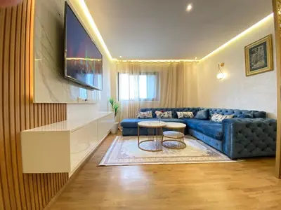 a living room with a blue couch and a table at Apartement agdal in Rabat