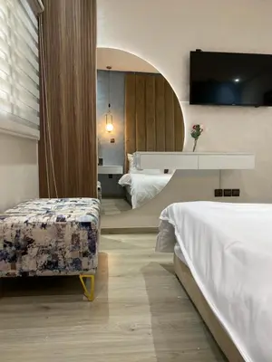 a hotel room with two beds and a table and a chair at Apartement agdal in Rabat