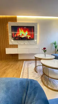a living room with a fireplace and two tables at Apartement agdal in Rabat