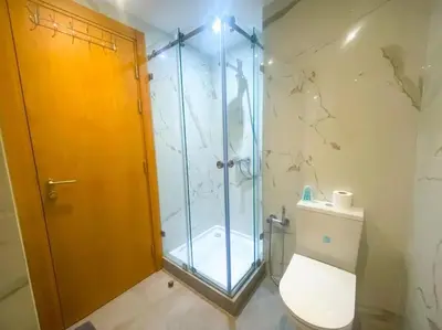 a bathroom with a glass shower and a toilet at 3BD Appart à 2 min Gare Agdal Luxe & Confort in Rabat