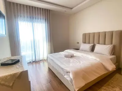 a bedroom with a large bed with a large window at 3BD Appart à 2 min Gare Agdal Luxe & Confort in Rabat