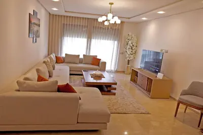 a living room with a couch and a tv at 3BD Appart à 2 min Gare Agdal Luxe & Confort in Rabat