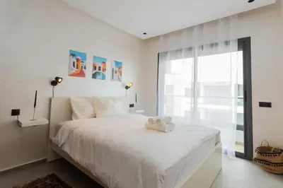 a bedroom with a white bed with a stuffed animal on it at Appartement cosy et moderne Bouskoura proche Aéroport et Hopital universitaire in Bouskoura